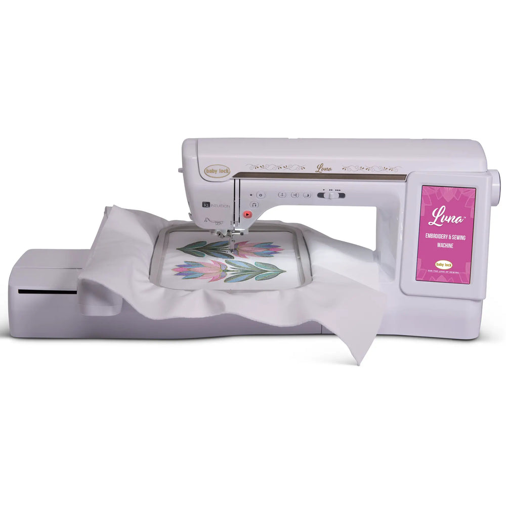 Baby Lock Luna sewing and embroidery machine, white with pink touchscreen panel and decorative gold accents.