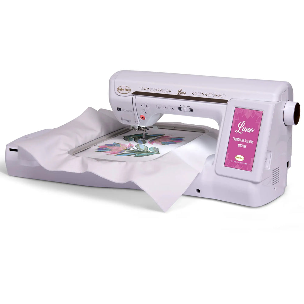 Baby Lock Luna sewing and embroidery machine; white body with pink accents and floral embroidery on fabric.