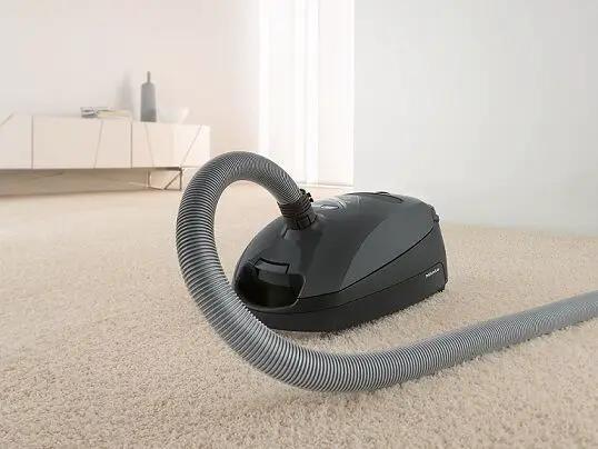 Miele canister vacuum, Classic C1 Pure Suction Graphite Grey, on carpet with hose