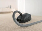 Miele canister vacuum, Classic C1 Pure Suction Graphite Grey, on carpet with hose