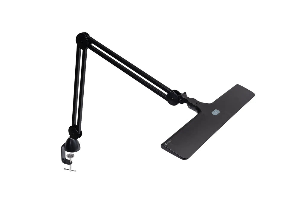 Lumi Task Lamp Satin Black by Daylight with adjustable arms and clamp base, plus desk mat.
