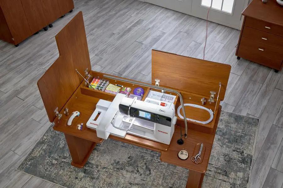 Koala Studios sewing station cabinet in teak finish, opened to reveal a Bernina sewing machine and accessories.