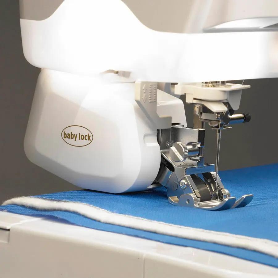 Baby Lock Digital Dual Feed presser foot on a sewing machine; white plastic with metal components over blue fabric.