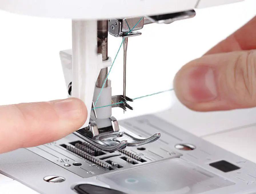 Singer Fashion Mate sewing machine (3333), white with teal thread being threaded by hands