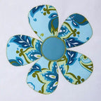 Flower-shaped pincushion in blue patterned fabric with a solid blue center.