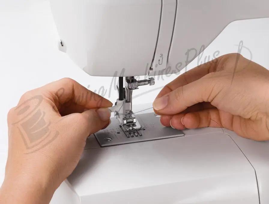 Singer 6199 Brilliance electronic sewing machine, white, hands guiding fabric.