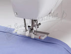 Singer 6199 Brilliance sewing machine stitching blue fabric; white electronic model.