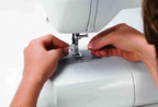 Singer Starlet Sewing Machine 6699, white; hands threading at the presser foot