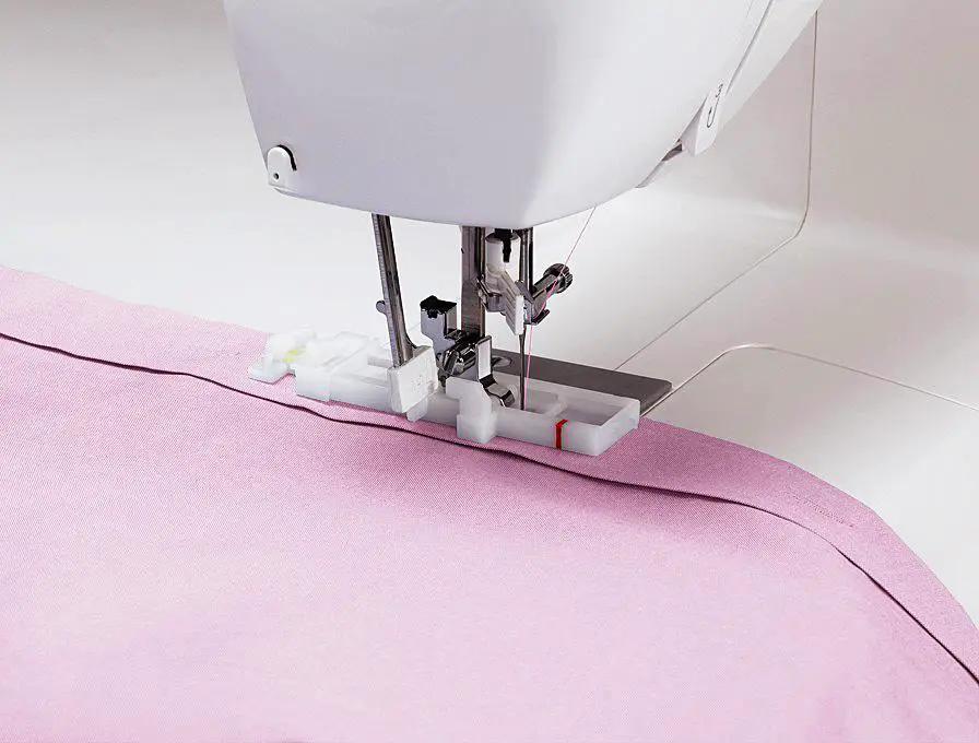 Singer Starlet sewing machine on pink fabric with white body and presser foot