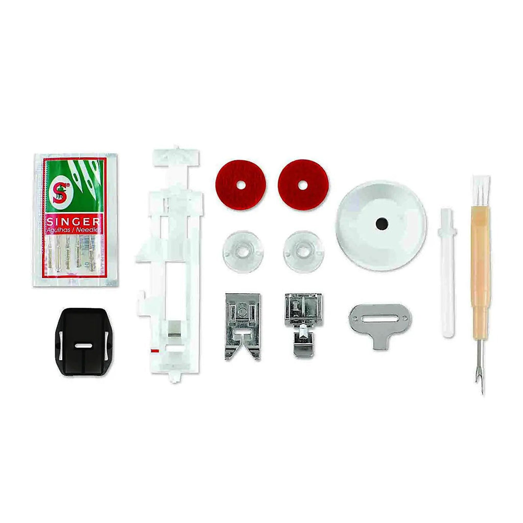 Singer Starlet sewing machine accessory kit in white with needles, presser feet, bobbins, red discs and tools