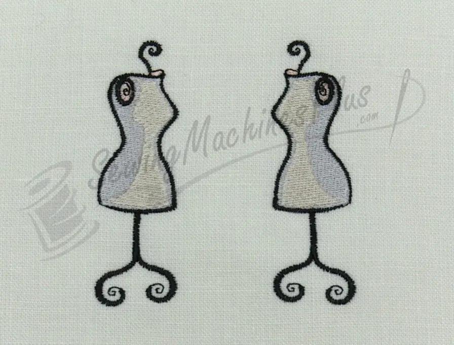 Embroidery design of two beige dress forms on white fabric