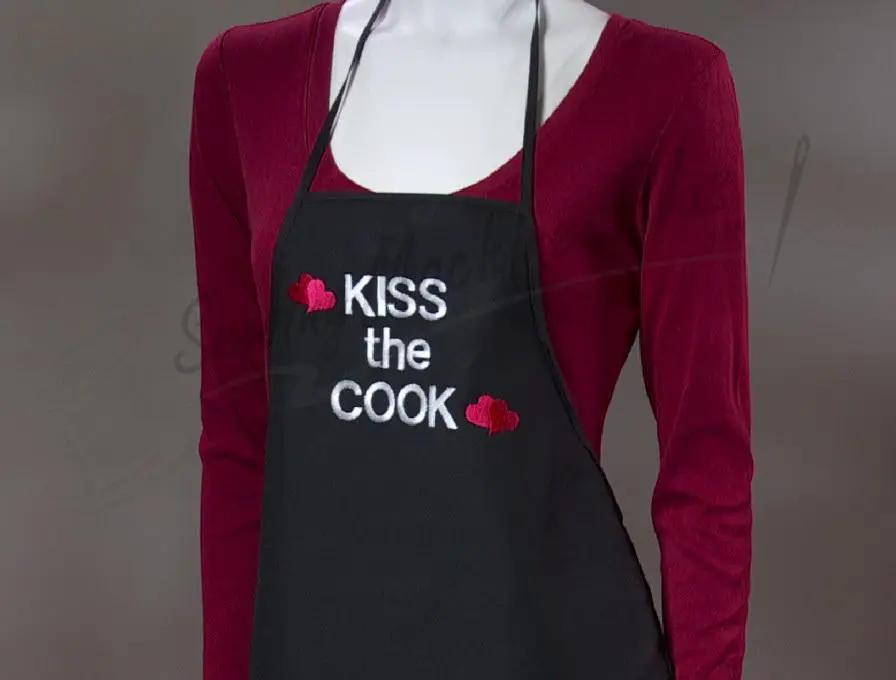 Apron in black with Kiss the Cook embroidery and red heart accents