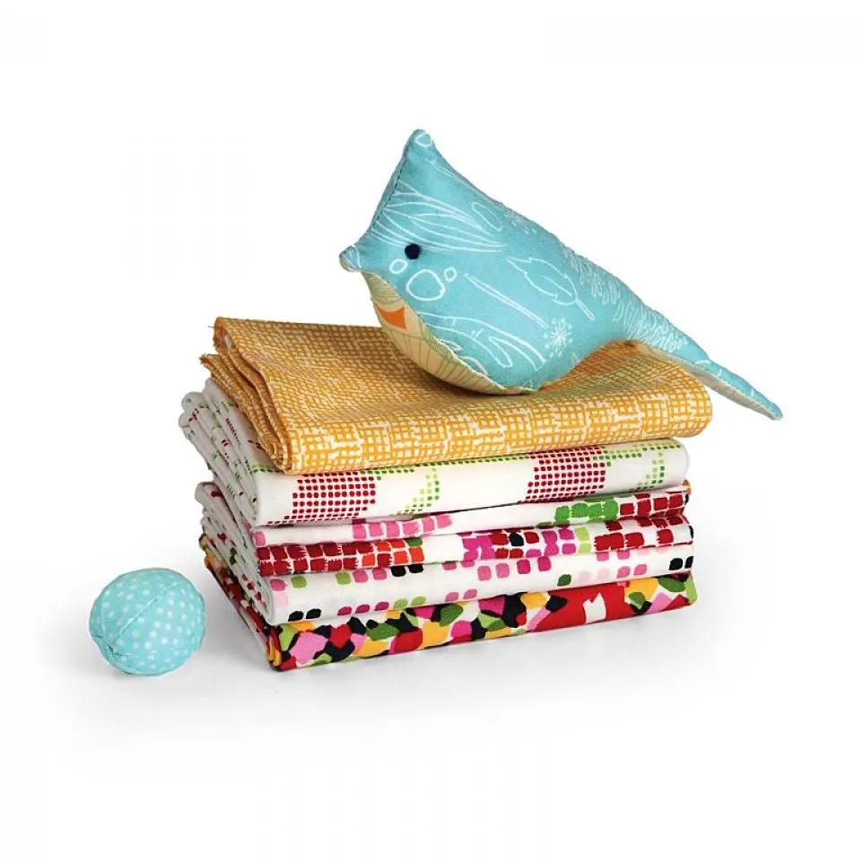 Sizzix Bigz L Die Bird and Egg; turquoise bird plush atop a stack of colorful quilts