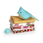 Sizzix Bigz L Die Bird and Egg; turquoise bird plush atop a stack of colorful quilts