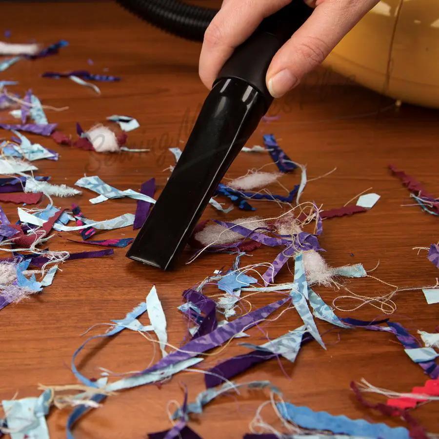 Carpet Pro Teeny Tiny Tank handheld vacuum SCT-1.2, black, cleaning colorful confetti on a wooden floor
