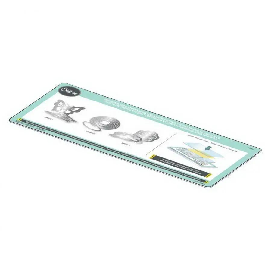 Sizzix Big Shot Express cutting machine display mat, white and gray with teal border, shows sample dies